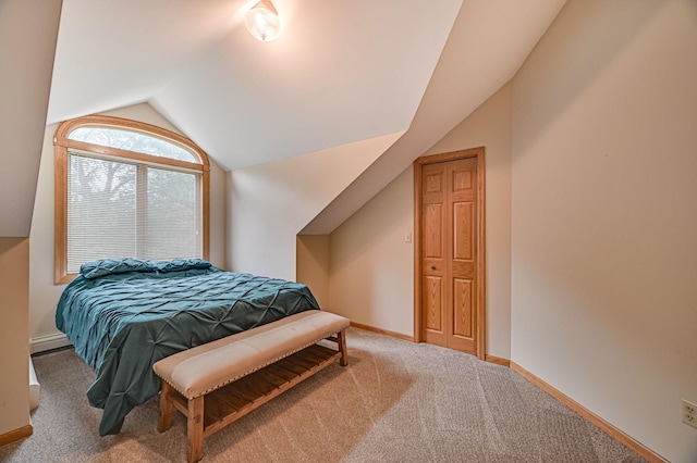 bedroom featuring lofted ceiling, a baseboard heating unit, and carpet flooring