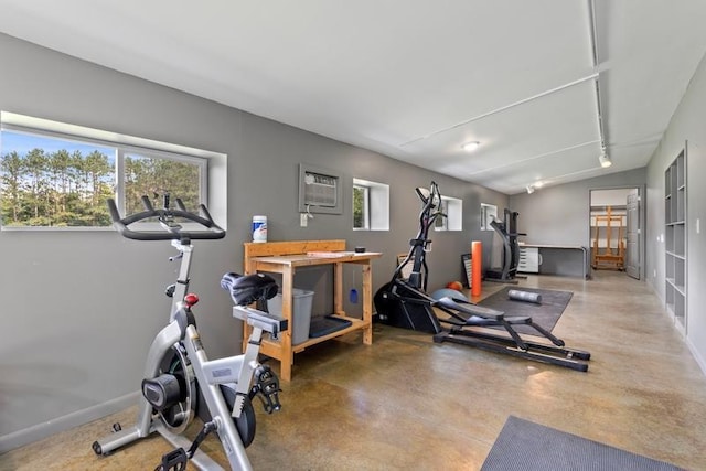 workout area with an AC wall unit and a healthy amount of sunlight