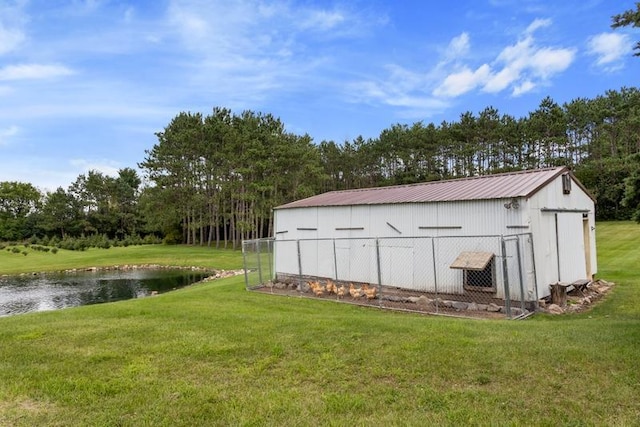 view of outbuilding with a yard and a water view