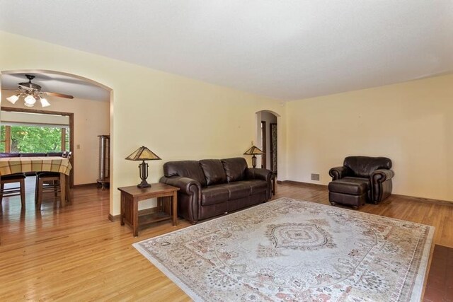 living room with ceiling fan and light wood-type flooring