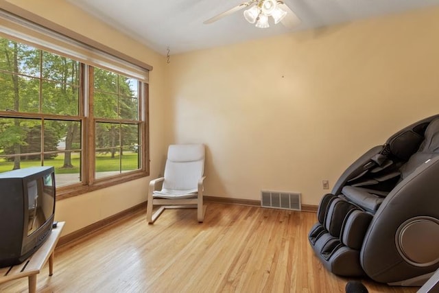 sitting room with ceiling fan and light hardwood / wood-style flooring