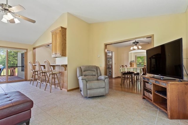 living room featuring lofted ceiling, light tile patterned floors, a wealth of natural light, and ceiling fan