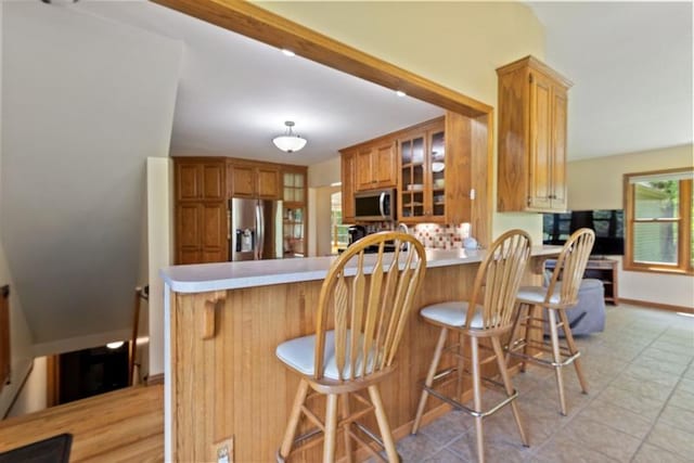 kitchen with appliances with stainless steel finishes, a breakfast bar, and kitchen peninsula