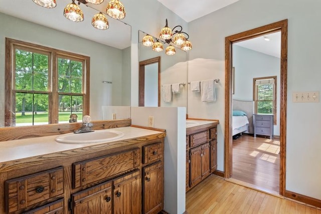 bathroom featuring vanity, hardwood / wood-style floors, and an inviting chandelier