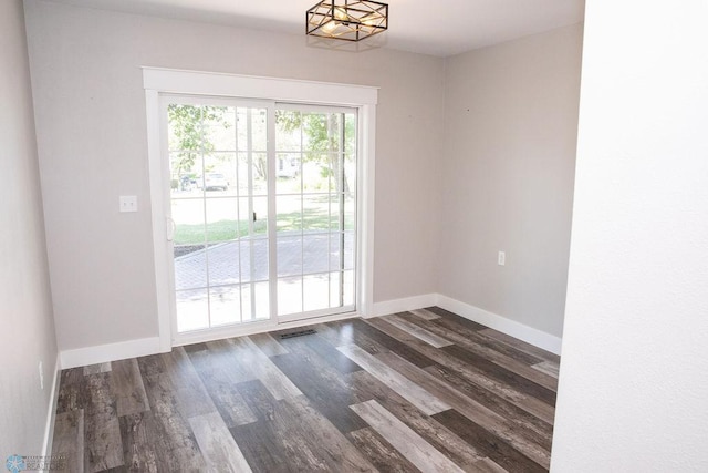 interior space with dark wood-type flooring, visible vents, and baseboards