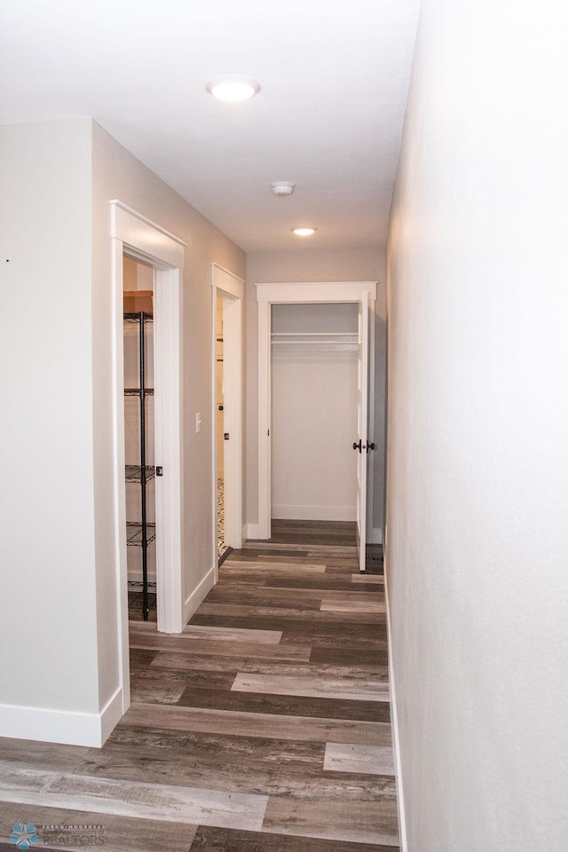 corridor featuring dark wood-style floors, baseboards, and recessed lighting