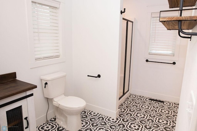 full bath with toilet, a stall shower, baseboards, and tile patterned floors