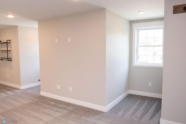 carpeted empty room featuring baseboards