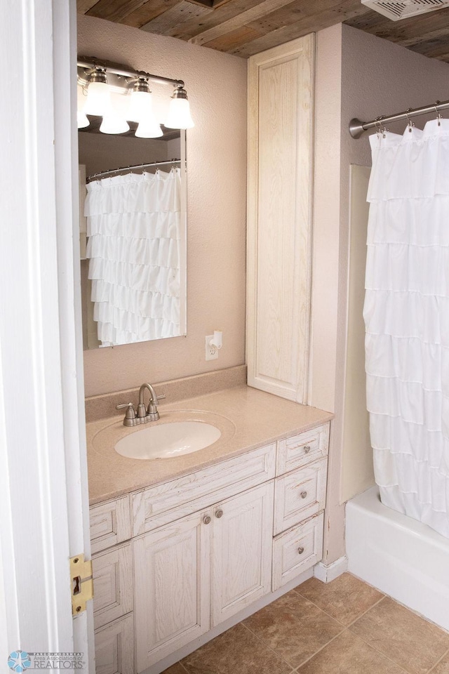 full bath featuring tile patterned flooring, shower / bath combo, and vanity