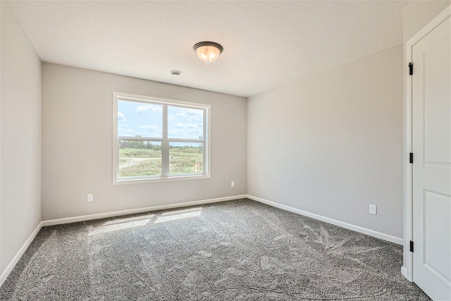 spare room featuring a textured ceiling and carpet floors