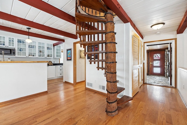 interior space with visible vents, beam ceiling, wood ceiling, and light wood finished floors