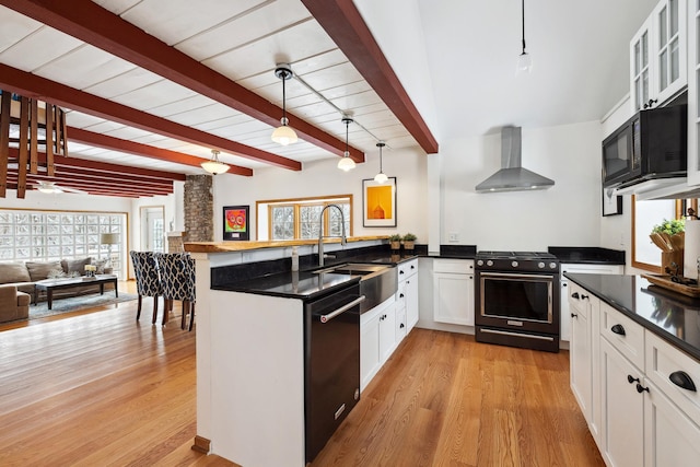 kitchen with dark countertops, a peninsula, black appliances, wall chimney exhaust hood, and a sink