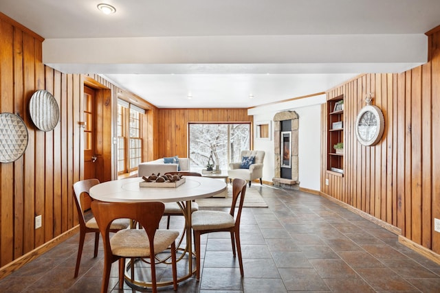 dining room featuring baseboards and wooden walls