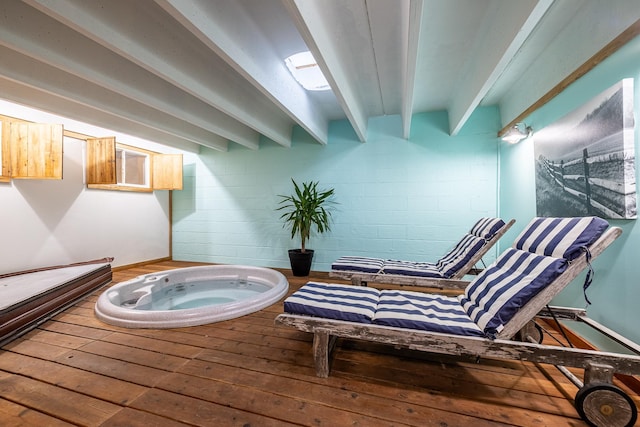 interior space with beam ceiling and concrete block wall