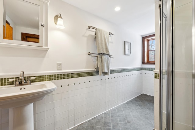 bathroom with tile patterned floors, a wainscoted wall, a sink, recessed lighting, and tile walls