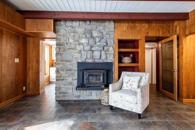 living area featuring wooden walls, built in shelves, baseboards, beamed ceiling, and wood ceiling