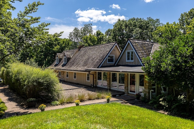 view of front of home featuring board and batten siding, a front yard, and stone siding