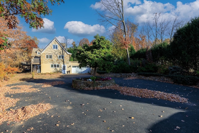 exterior space featuring aphalt driveway and stone siding