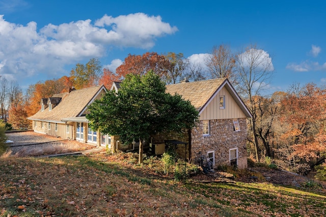 view of home's exterior with stone siding and a chimney