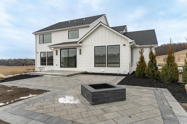 rear view of house with a fire pit and a patio area