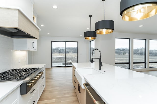 kitchen featuring white cabinetry, decorative light fixtures, tasteful backsplash, and appliances with stainless steel finishes