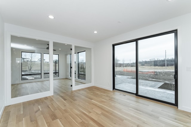 empty room with light hardwood / wood-style floors and a healthy amount of sunlight