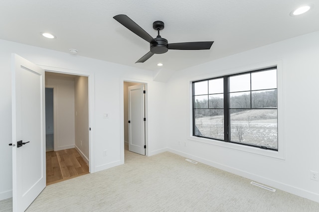 unfurnished bedroom with ceiling fan and light carpet