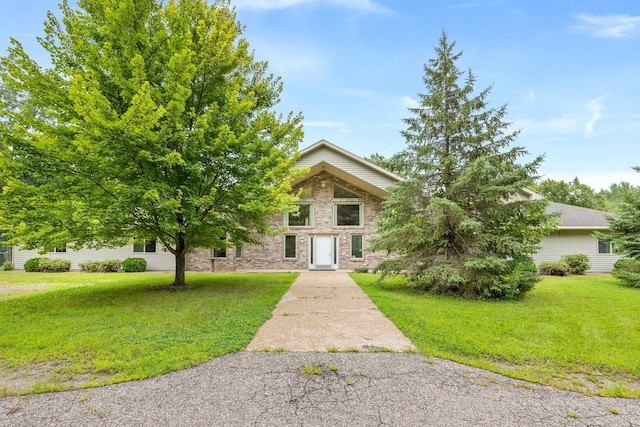 view of property hidden behind natural elements featuring a front yard