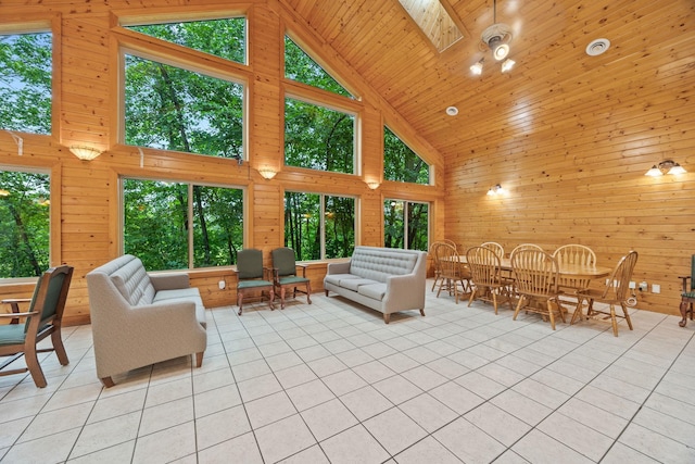 tiled living room featuring wooden ceiling, high vaulted ceiling, wooden walls, and a skylight