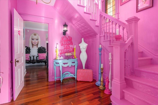 stairs with ornamental molding and wood-type flooring