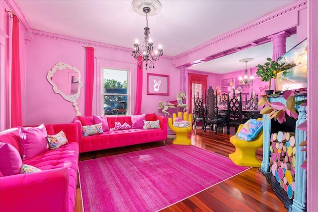 living room with wood-type flooring, a chandelier, ornate columns, and ornamental molding