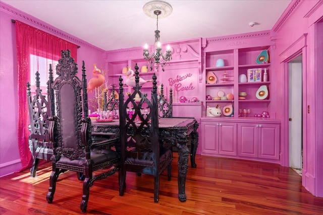 dining area featuring built in shelves, hardwood / wood-style floors, crown molding, and a chandelier