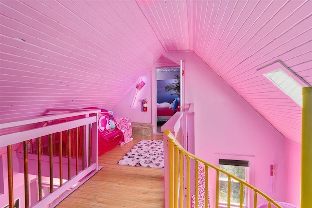 bedroom with lofted ceiling with skylight, wood ceiling, and light hardwood / wood-style floors