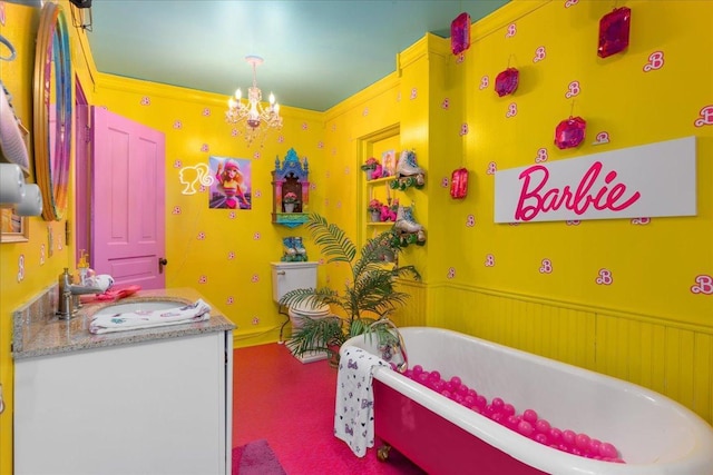 bathroom featuring vanity, an inviting chandelier, a bath, and crown molding