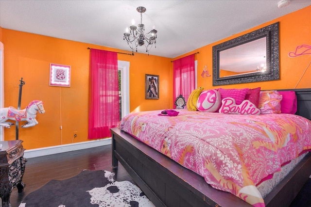 bedroom with dark hardwood / wood-style floors and an inviting chandelier