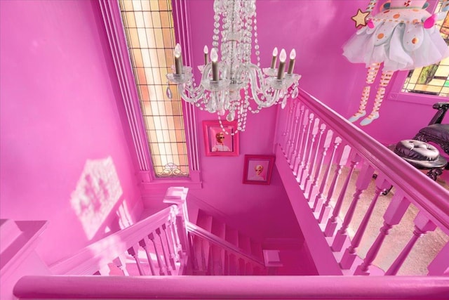 staircase featuring an inviting chandelier