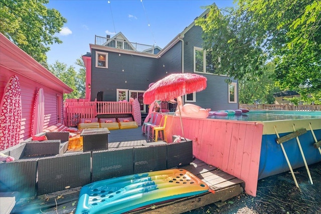 rear view of property featuring an outdoor hangout area and a pool side deck