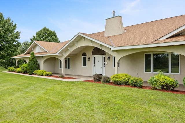 69531-1 213th St, Darwin, MN 55324 - view of front facade with a front lawn, stucco siding, roof with shingles, and a chimney