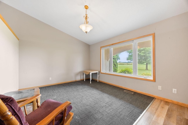 spare room with vaulted ceiling and hardwood / wood-style floors