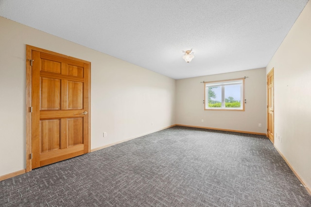 carpeted empty room featuring a textured ceiling