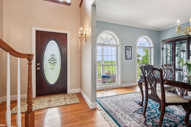 foyer entrance with visible vents, stairway, baseboards, and wood finished floors