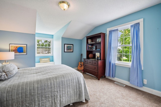 carpeted bedroom featuring lofted ceiling, visible vents, a textured ceiling, and baseboards