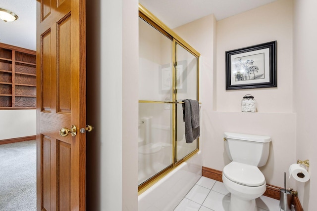 bathroom featuring baseboards, enclosed tub / shower combo, toilet, and tile patterned floors