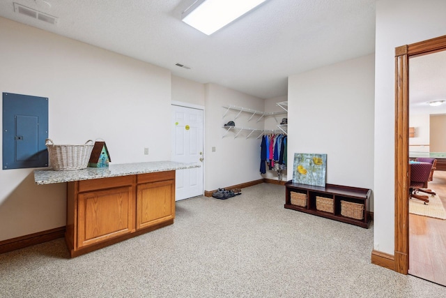 laundry room with baseboards, electric panel, and visible vents