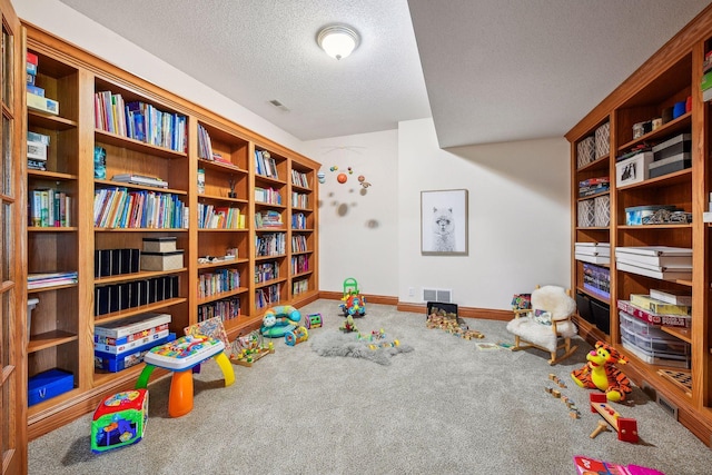 rec room with a textured ceiling, carpet flooring, visible vents, and baseboards