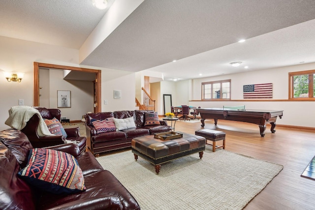 living area featuring billiards, baseboards, wood finished floors, stairs, and a textured ceiling