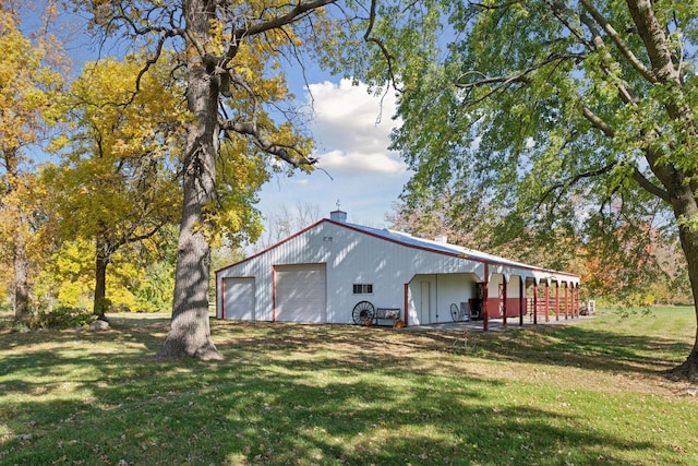 exterior space with an outbuilding, a pole building, a yard, and a detached garage