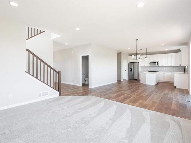 unfurnished living room with sink and hardwood / wood-style floors