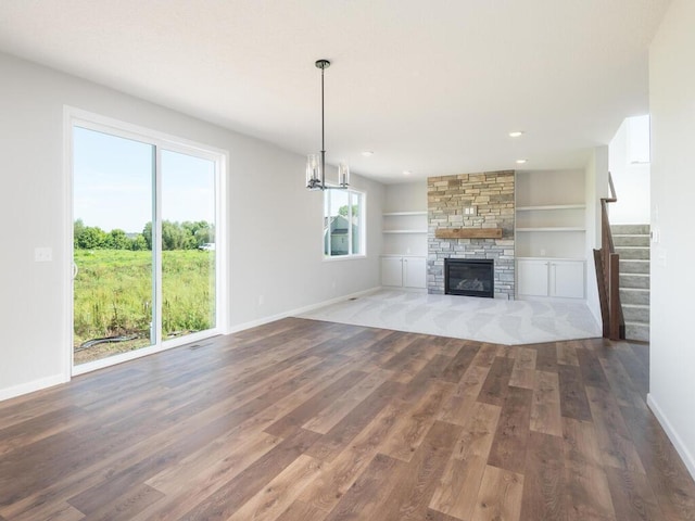 unfurnished living room featuring dark hardwood / wood-style floors, plenty of natural light, and built in shelves