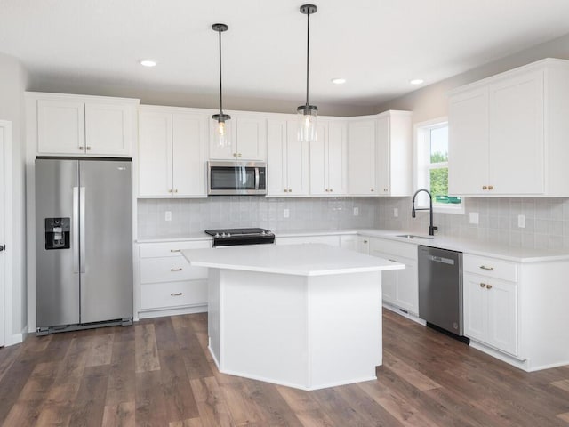 kitchen featuring dark wood-type flooring, stainless steel appliances, white cabinetry, and pendant lighting